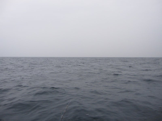 alt="鉛色の冬空と水平線の風景"